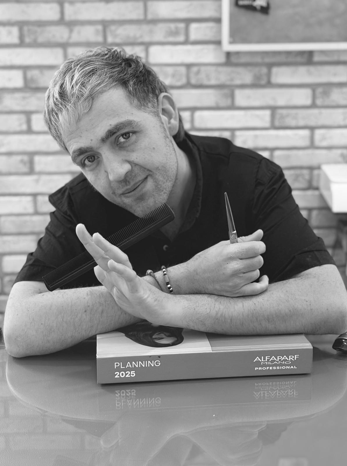 Marino, titolare del salone, con pettine e forbici